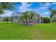 Beautiful screened-in pool area with lush landscaping, mature trees, and open backyard space at 5750 Saddle Oak Trl, Sarasota, FL 34241