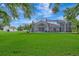 View of the screened pool area and backyard with lush grass and surrounding greenery at 5750 Saddle Oak Trl, Sarasota, FL 34241