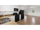 Modern kitchen with white cabinets, black appliances, and open access to the living area at 5798 Kenwood Dr, North Port, FL 34287