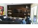 Comfortable living room features a dark wood entertainment center with built-in shelving and a large TV at 7323 Great Egret Blvd, Sarasota, FL 34241