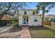 Charming two-story home with a brick walkway, stucco exterior, a palm tree and a blue front door at 820 Groveland Ave, Venice, FL 34285