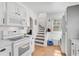 Bright kitchen boasts wooden floors, white cabinets and appliances, plus convenient stair access at 820 Groveland Ave, Venice, FL 34285