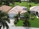 Aerial view of a well-maintained home with a tile roof, lush landscaping, and a two-car garage at 8503 Gateway Ct, Englewood, FL 34224