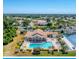 Aerial view of a community pool, clubhouse, and tennis courts surrounded by lush landscaping and residential homes at 8503 Gateway Ct, Englewood, FL 34224
