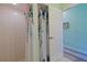 This is a full bathroom with a walk-in shower with floral curtains and clean showerhead at 8503 Gateway Ct, Englewood, FL 34224