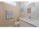 This is a clean half bath with a white vanity and sink, with decorative tile and mirror at 8503 Gateway Ct, Englewood, FL 34224