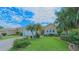 Beautiful single-story home featuring lush landscaping, a well-manicured lawn, and mature trees at 8503 Gateway Ct, Englewood, FL 34224