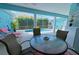 Outdoor seating area with a glass table, chairs and screened-in pool at 8503 Gateway Ct, Englewood, FL 34224