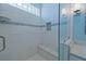 Newly renovated shower with glass enclosure, built-in bench, and decorative tile accents at 8503 Gateway Ct, Englewood, FL 34224