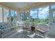 Bright sunroom with large windows, comfortable seating, and serene views at 8503 Gateway Ct, Englewood, FL 34224
