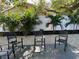 Relaxing backyard with three chairs on a concrete patio and a white fence at 1041 S Tuttle Ave, Sarasota, FL 34237