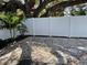 Backyard featuring a white vinyl fence, tropical plants, gravel ground cover, and stepping stones at 1041 S Tuttle Ave, Sarasota, FL 34237