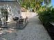 Backyard patio area with chairs, fire pit, and a white fence bordering the gravel-covered yard at 1041 S Tuttle Ave, Sarasota, FL 34237