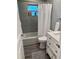 Updated bathroom with a shower/tub combo, white vanity, and gray tile at 1041 S Tuttle Ave, Sarasota, FL 34237
