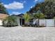 Charming single-story home featuring a beautifully landscaped front yard with a brick driveway, green plants, and a white fence at 1041 S Tuttle Ave, Sarasota, FL 34237
