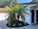 Beautifully landscaped front yard with palm trees and fresh mulch welcomes you to the property at 1041 S Tuttle Ave, Sarasota, FL 34237
