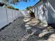 A side yard featuring gravel ground cover and a white vinyl fence at 1041 S Tuttle Ave, Sarasota, FL 34237
