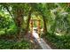 Lush backyard featuring a stone pathway leading to a wooden archway in a verdant setting at 1125 W Peppertree Dr # 706, Sarasota, FL 34242