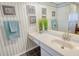 Charming bathroom featuring a vanity with marble countertops, decorative art and black tile flooring at 1125 W Peppertree Dr # 706, Sarasota, FL 34242