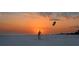 Sunset view of a Personal flying a kite on the beach with a colorful sky at 1125 W Peppertree Dr # 706, Sarasota, FL 34242