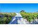 Beach access trail through lush vegetation leading to beautiful white sand at 1125 W Peppertree Dr # 706, Sarasota, FL 34242