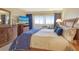 Bedroom with blue bedding, a wooden dresser and a view of the outdoor cityscape at 1125 W Peppertree Dr # 706, Sarasota, FL 34242