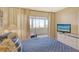 Bright bedroom featuring balcony access with a cozy ambiance and a television at 1125 W Peppertree Dr # 706, Sarasota, FL 34242