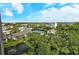 Scenic community view with lush greenery, buildings, tennis court, and blue sky at 1125 W Peppertree Dr # 706, Sarasota, FL 34242