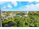 Scenic community view with lush greenery, buildings, tennis court, and blue sky at 1125 W Peppertree Dr # 706, Sarasota, FL 34242