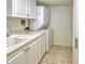 A practical laundry room including a washer and dryer and a sink with white cabinetry at 1125 W Peppertree Dr # 706, Sarasota, FL 34242