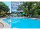Beautiful pool with ample lounge chairs and an adjacent high-rise at 1125 W Peppertree Dr # 706, Sarasota, FL 34242