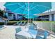 Pool deck featuring patio seating, lounge chairs, and lush tropical plants at 1125 W Peppertree Dr # 706, Sarasota, FL 34242