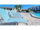 Lounge chairs beside community pool with surrounding landscaping and building in the background at 1125 W Peppertree Dr # 706, Sarasota, FL 34242