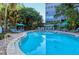 Community pool area with chaise lounges and tropical trees at 1125 W Peppertree Dr # 706, Sarasota, FL 34242