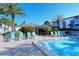 Community pool surrounded by lush landscaping, lounge chairs, and tropical palms at 1125 W Peppertree Dr # 706, Sarasota, FL 34242