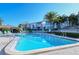 Community pool surrounded by lush landscaping, lounge chairs, and tropical palms at 1125 W Peppertree Dr # 706, Sarasota, FL 34242