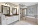 Elegant bathroom featuring double vanities, a glass-enclosed shower, and a soaking tub at 11254 Rivers Bluff Cir, Lakewood Ranch, FL 34202