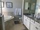 Serene bathroom featuring a garden tub, double vanity with granite counters, and tile flooring for a luxurious feel at 12229 Amica Loop, Venice, FL 34293