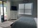 Cozy bedroom featuring a comfortable bed, dresser with TV, and an access door to the patio, creating a relaxing retreat at 12229 Amica Loop, Venice, FL 34293