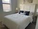 Bedroom with a bed, side tables, window with blinds, and coastal themed decor at 12229 Amica Loop, Venice, FL 34293