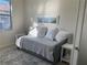 Bright bedroom featuring a daybed with decorative pillows, side table and a large window at 12229 Amica Loop, Venice, FL 34293