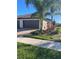 Charming single Gathering home featuring a barrel tile roof, brick paver driveway, and mature tropical landscaping at 12229 Amica Loop, Venice, FL 34293