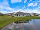 Backyard view of a house near a pond in a residential community at 12518 Oak Hill Way, Parrish, FL 34219