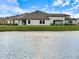 Back of house with a view of a lake and expansive lawn at 12518 Oak Hill Way, Parrish, FL 34219