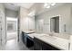 Bright bathroom features double sinks, a large mirror and a doorway to the bedroom at 12518 Oak Hill Way, Parrish, FL 34219