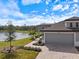 Beautiful exterior view of home with a three-car garage, landscaped yard, and serene pond in the backyard at 12518 Oak Hill Way, Parrish, FL 34219