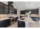 Modern kitchen with stainless steel appliances, dark cabinets, and a kitchen island at 12518 Oak Hill Way, Parrish, FL 34219