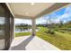 Covered patio overlooking a serene lake with lush greenery and blue skies at 12518 Oak Hill Way, Parrish, FL 34219