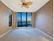 Empty bedroom with wall-to-wall carpeting, large windows with an ocean view, and fan at 1281 Gulf Of Mexico Dr # 703, Longboat Key, FL 34228