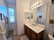 Bathroom showcasing a white countertop sink vanity, neutral walls, and a large window with natural light at 13602 Abercrombie Dr, Englewood, FL 34223